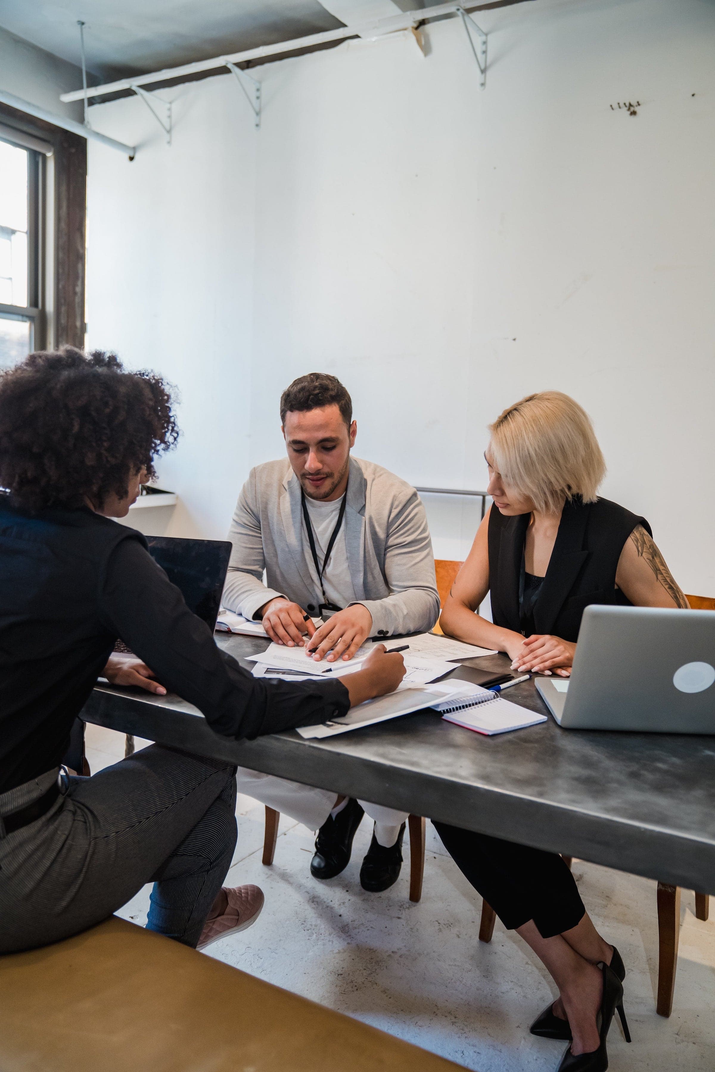 Three individuals looking over documents at a table.